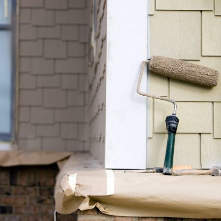 Paint Roller, Brush and Putty Knife rest near New Siding